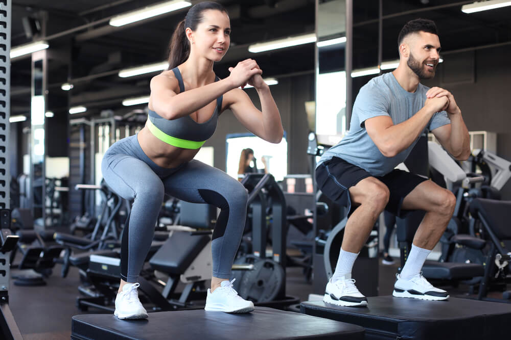 Fit couple doing jumping squats