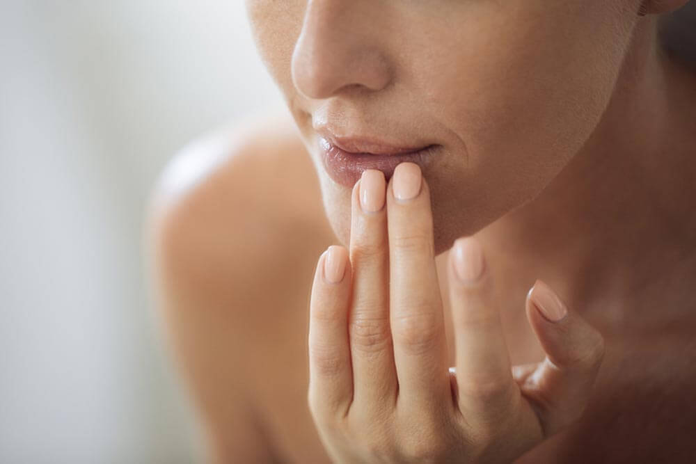 woman putting balm on her lips