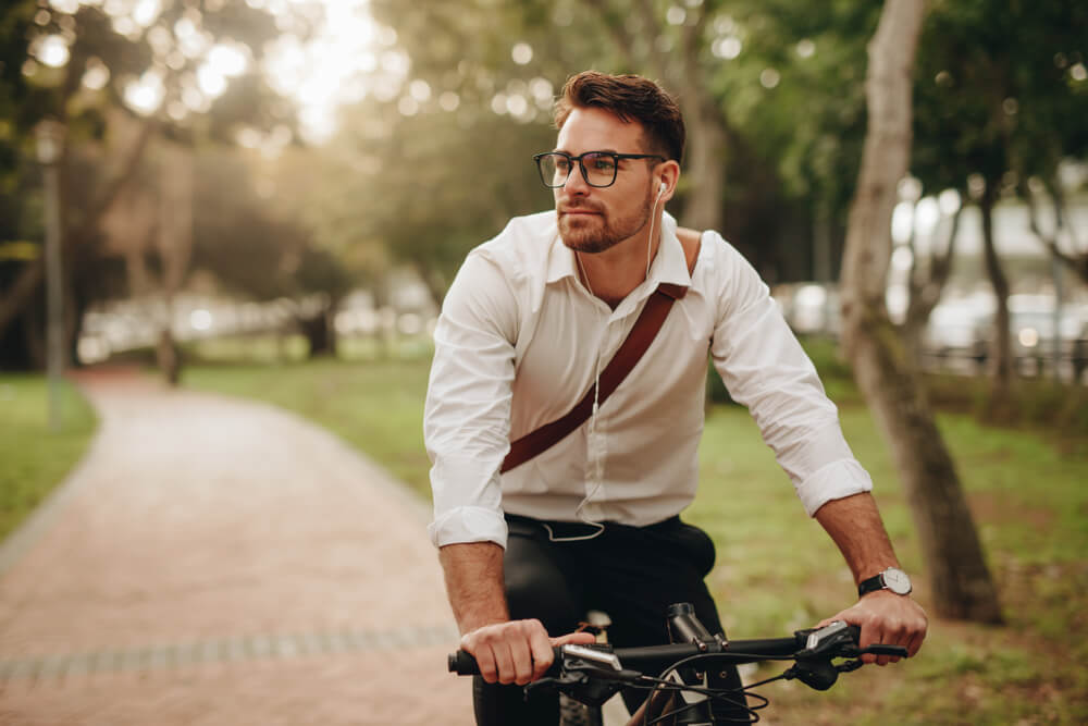 Man enjoying music using earphones while commuting to office on a bicycle