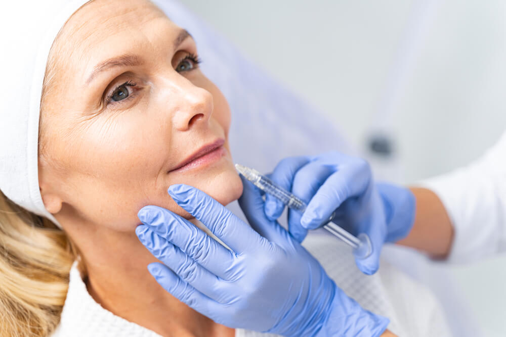 mature woman receiving a beauty injection in her bottom lip